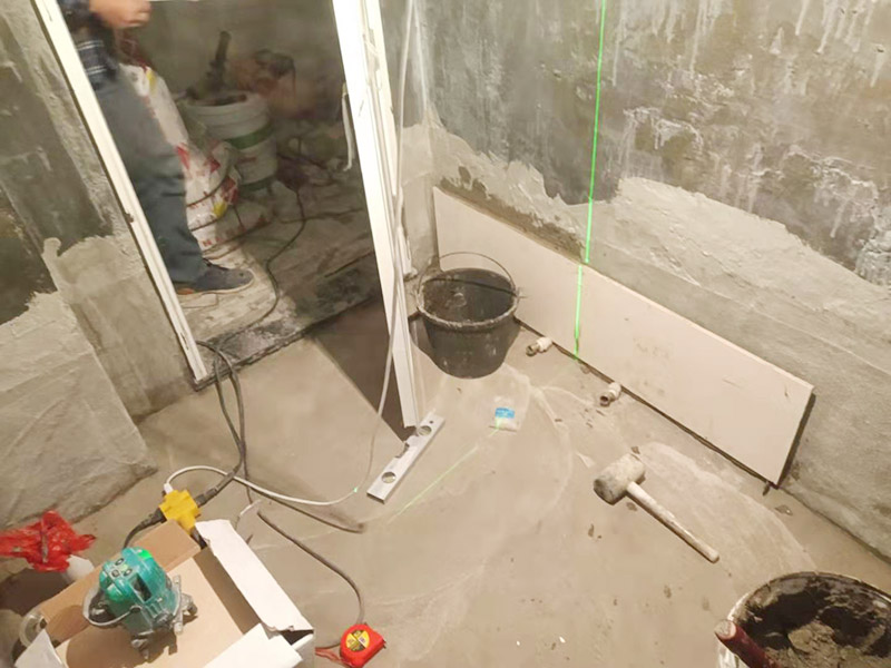 衛(wèi)生間墻面貼磚：施工前將需要的材料整齊堆放在一旁待用。首先應(yīng)除去基層表面的污垢，油漬，浮灰;除去基層上所有涂料層，膩?zhàn)訉?如果基層未能達(dá)到平整度要求，需對基層進(jìn)行預(yù)先的找平處理。 鋪貼瓷磚前需事先找好垂直線，以此為基準(zhǔn)鋪貼的瓷磚高低均勻、垂直美觀;此外，施工前在墻體四周需彈出標(biāo)高控制線，在地面彈出十字線，以控制地磚分隔尺寸。 加水后將粘結(jié)劑漿料攪拌至潤滑均勻，無明顯塊狀或糊狀結(jié)塊，攪拌后的漿料靜置5-10分鐘后再稍加攪拌1-2分鐘即可使用。在開始鋪貼施工前，需要先清理瓷磚表面的浮灰，污垢等。將調(diào)制好的漿料均勻地抹在瓷磚背面，要求漿料飽滿。將瓷磚平整地鋪貼在基層上，使用橡膠錘將瓷磚拍實(shí)鋪平。施工過程中，可小幅度轉(zhuǎn)動(dòng)瓷磚，使?jié){料與瓷磚背面充分接觸。