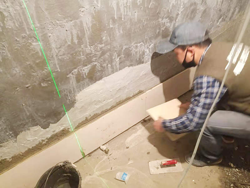 衛(wèi)生間墻面貼磚：施工前將需要的材料整齊堆放在一旁待用。首先應(yīng)除去基層表面的污垢，油漬，浮灰;除去基層上所有涂料層，膩?zhàn)訉?如果基層未能達(dá)到平整度要求，需對基層進(jìn)行預(yù)先的找平處理。 鋪貼瓷磚前需事先找好垂直線，以此為基準(zhǔn)鋪貼的瓷磚高低均勻、垂直美觀;此外，施工前在墻體四周需彈出標(biāo)高控制線，在地面彈出十字線，以控制地磚分隔尺寸。 加水后將粘結(jié)劑漿料攪拌至潤滑均勻，無明顯塊狀或糊狀結(jié)塊，攪拌后的漿料靜置5-10分鐘后再稍加攪拌1-2分鐘即可使用。在開始鋪貼施工前，需要先清理瓷磚表面的浮灰，污垢等。將調(diào)制好的漿料均勻地抹在瓷磚背面，要求漿料飽滿。將瓷磚平整地鋪貼在基層上，使用橡膠錘將瓷磚拍實(shí)鋪平。施工過程中，可小幅度轉(zhuǎn)動(dòng)瓷磚，使?jié){料與瓷磚背面充分接觸。